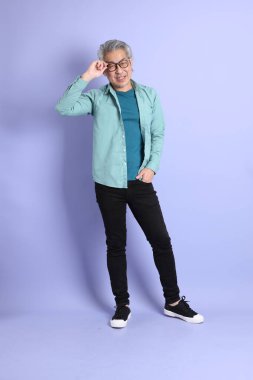 Mor arka planda duran yaşlı Asyalı adamın boyu....