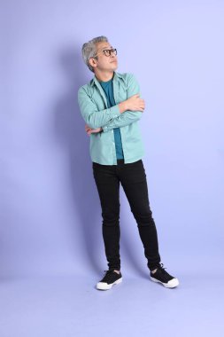 Mor arka planda duran yaşlı Asyalı adamın boyu....