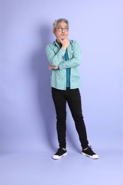 Mor arka planda duran yaşlı Asyalı adamın boyu....