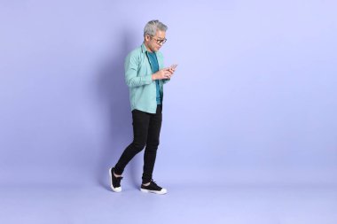 Mor arka planda duran yaşlı Asyalı adamın boyu....