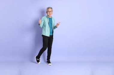 Mor arka planda duran yaşlı Asyalı adamın boyu....