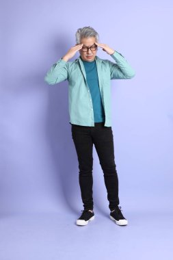 Mor arka planda duran yaşlı Asyalı adamın boyu....