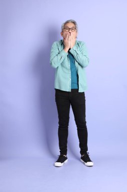 Mor arka planda duran yaşlı Asyalı adamın boyu....