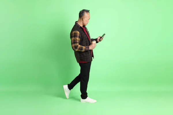 stock image The 40s adult Asian man with plaid shirt standing on the green background.