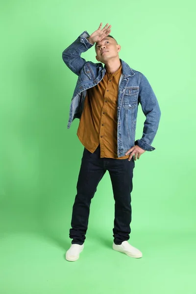stock image The 40s adult Asian man with jean shirt standing on the green background.
