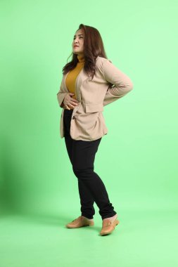 Yeşil arka planda duran Asyalı yetişkin iş kadını..