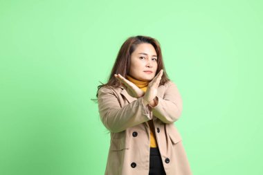 Yeşil arka planda duran Asyalı yetişkin iş kadını..