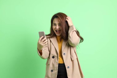 Yeşil arka planda duran Asyalı yetişkin iş kadını..