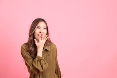The young adult Asian woman with brown dressed standing on the pink background.