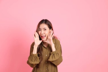 The young adult Asian woman with brown dressed standing on the pink background.