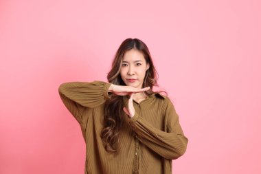 The young adult Asian woman with brown dressed standing on the pink background.