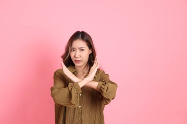 The young adult Asian woman with brown dressed standing on the pink background.