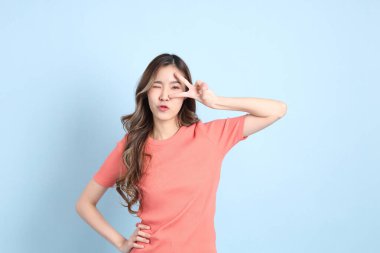 The young adult Asian woman with casual clothes with jeans standing on the blue background.