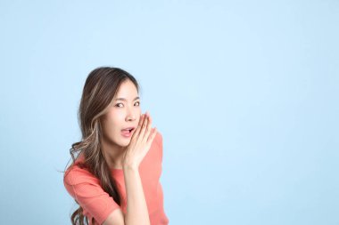 The young adult Asian woman with casual clothes with jeans standing on the blue background.