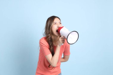 The young adult Asian woman with casual clothes with jeans standing on the blue background.