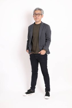 The senior Asian man with grey hair standing on the white background.