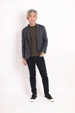 The senior Asian man with grey hair standing on the white background.