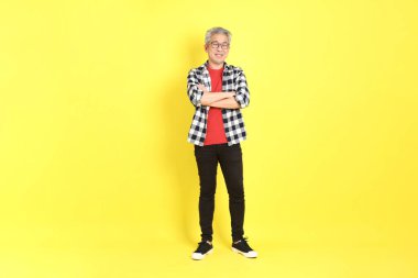 The 40s adult Asian man with casual dressed standing on the yellow background.