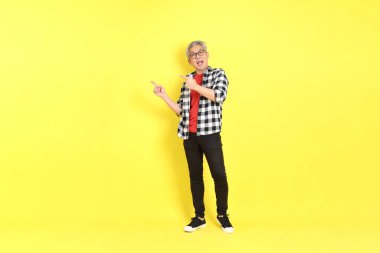 The 40s adult Asian man with casual dressed standing on the yellow background.