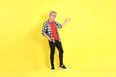 The 40s adult Asian man with casual dressed standing on the yellow background.