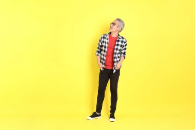 The 40s adult Asian man with casual dressed standing on the yellow background.