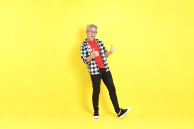 The 40s adult Asian man with casual dressed standing on the yellow background.