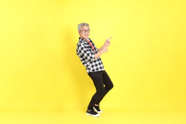The 40s adult Asian man with casual dressed standing on the yellow background.