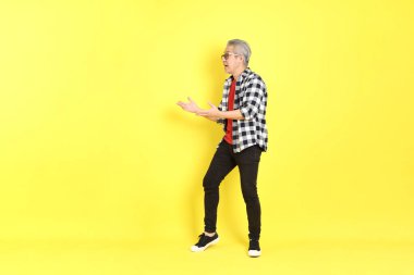 The 40s adult Asian man with casual dressed standing on the yellow background.