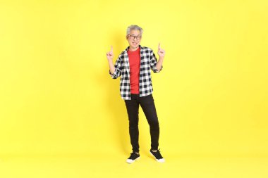 The 40s adult Asian man with casual dressed standing on the yellow background.