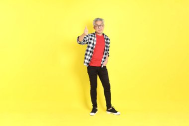 The 40s adult Asian man with casual dressed standing on the yellow background.