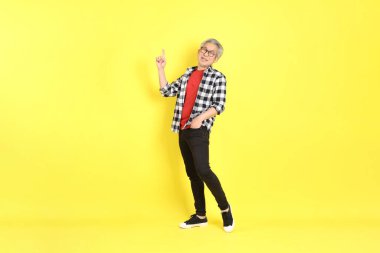 The 40s adult Asian man with casual dressed standing on the yellow background.