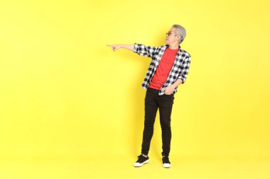 The 40s adult Asian man with casual dressed standing on the yellow background.