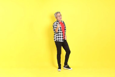 The 40s adult Asian man with casual dressed standing on the yellow background.