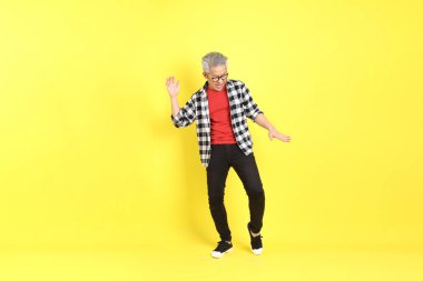 The 40s adult Asian man with casual dressed standing on the yellow background.