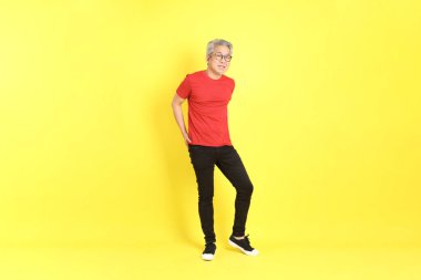 The 40s adult Asian man with casual dressed standing on the yellow background.