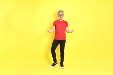 The 40s adult Asian man with casual dressed standing on the yellow background.