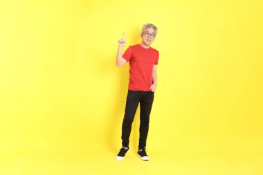 The 40s adult Asian man with casual dressed standing on the yellow background.