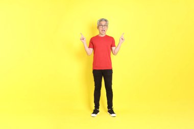 The 40s adult Asian man with casual dressed standing on the yellow background.