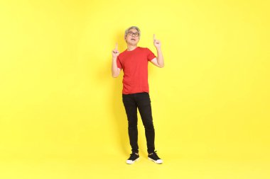 The 40s adult Asian man with casual dressed standing on the yellow background.