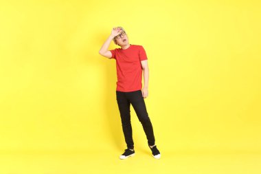The 40s adult Asian man with casual dressed standing on the yellow background.