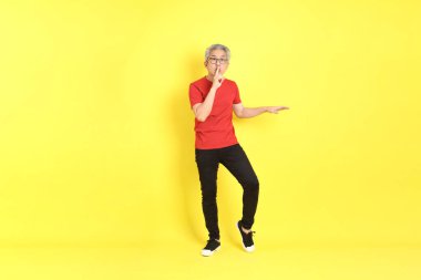 The 40s adult Asian man with casual dressed standing on the yellow background.