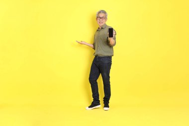 The 40s adult Asian man with casual dressed standing on the yellow background.