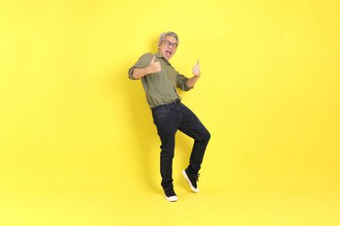 The 40s adult Asian man with casual dressed standing on the yellow background.