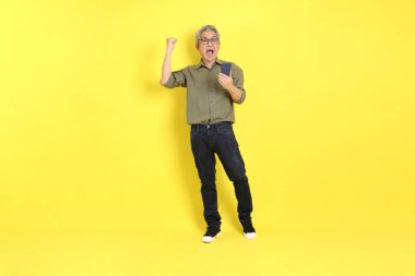 The 40s adult Asian man with casual dressed standing on the yellow background.
