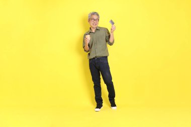 The 40s adult Asian man with casual dressed standing on the yellow background.