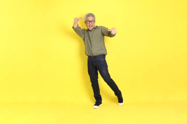 The 40s adult Asian man with casual dressed standing on the yellow background.