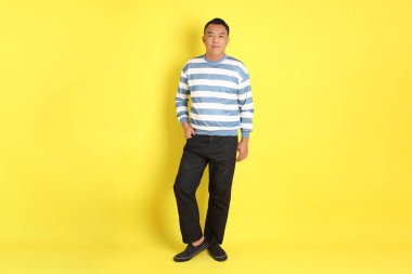 The 40s adult Asian man with standing on the yellow background.