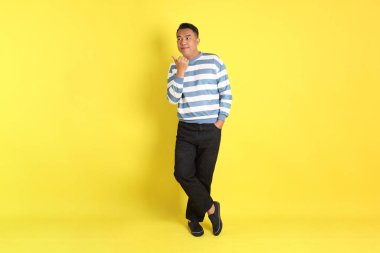 The 40s adult Asian man with standing on the yellow background.