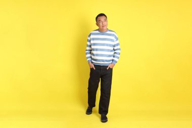 The 40s adult Asian man with standing on the yellow background.