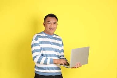 The 40s adult Asian man with standing on the yellow background.